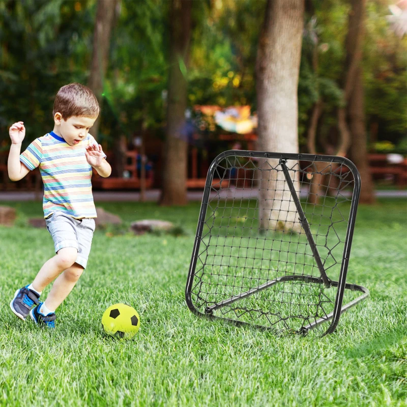 Young boy kicking soccer ball toward rebounder net in backyard.