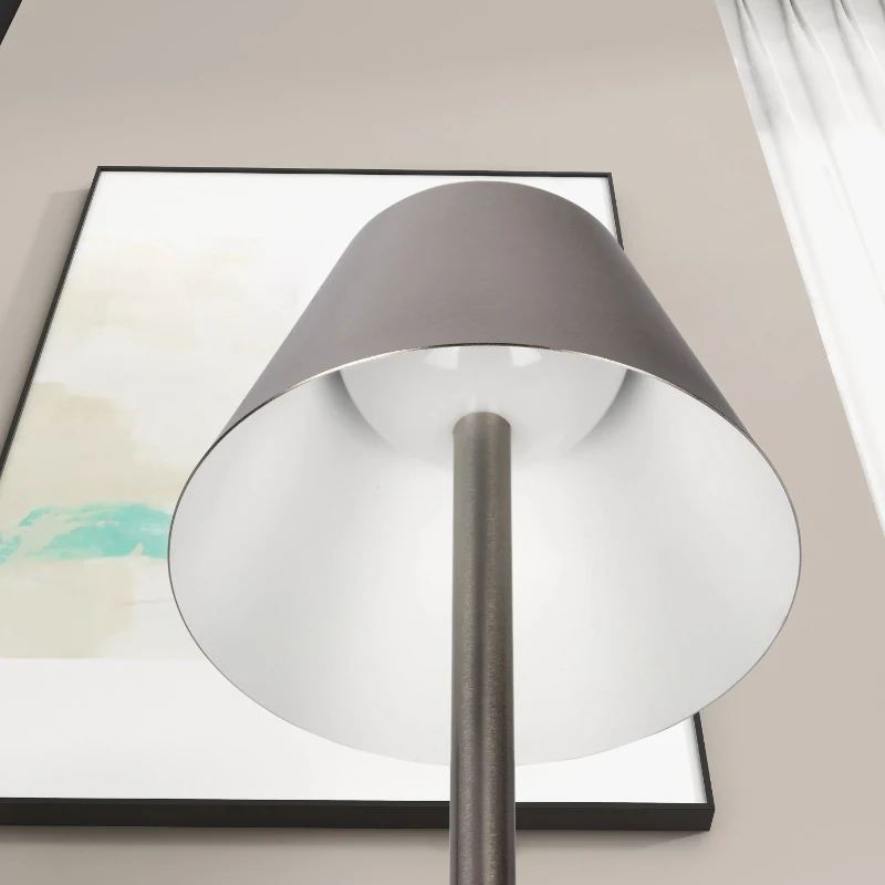 Silver lampshade with white interior viewed from below near wall art.