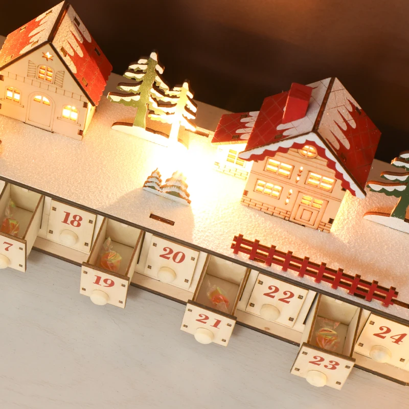 Close-up of lit wooden village advent calendar drawers.
