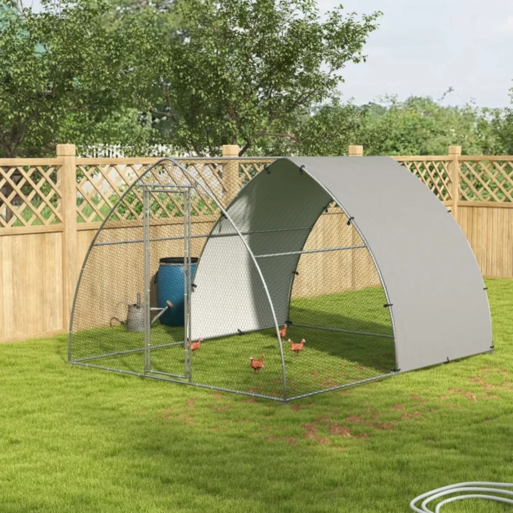 Walk-in metal dome chicken run enclosure with wire mesh and sun shade in a green yard.
