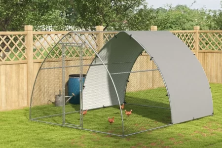 Walk-in metal dome chicken run enclosure with wire mesh and sun shade in a green yard.