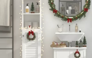 White bathroom decorated with wreaths, garlands, mini trees, and warm fairy lights.