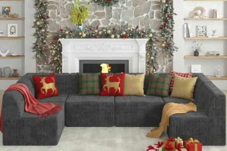 Dark sectional sofa with Christmas pillows, garland, wreath, and wrapped gifts.