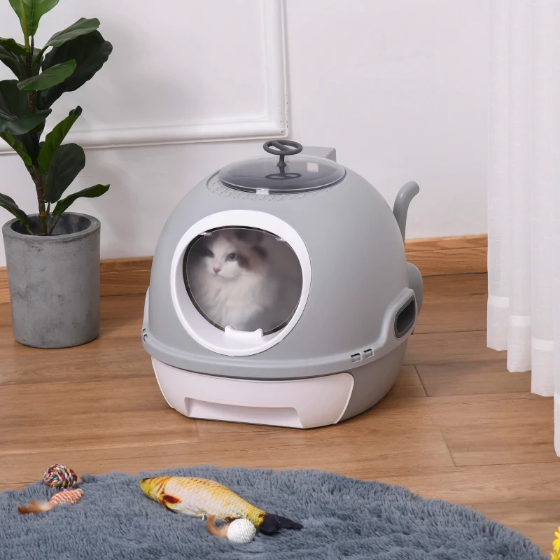 Cat sitting inside a modern covered litter box placed in a clean indoor room.
