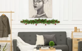 Festive wall art framed with garlands displayed above a modern sofa in a decorated living room.