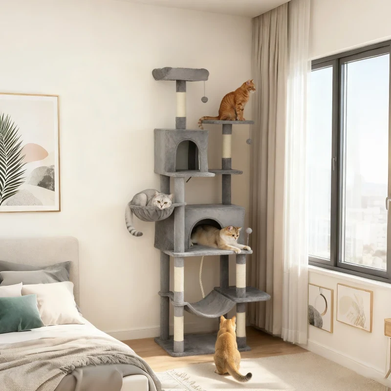 Three cats lounging on a multi-level grey cat tree set beside a bright window.
