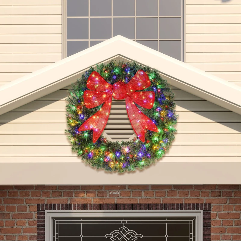 Large outdoor Christmas wreath with colorful lights and red bow.