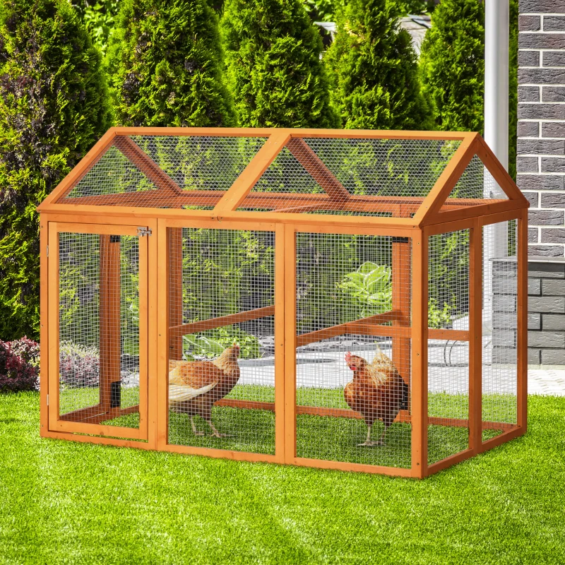 Small wooden chicken run with wire mesh walls and roof on a bright green lawn.