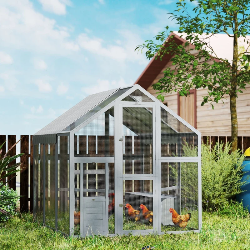 Gray wooden and mesh walk-in chicken run with a sloped roof in a sunny backyard.
