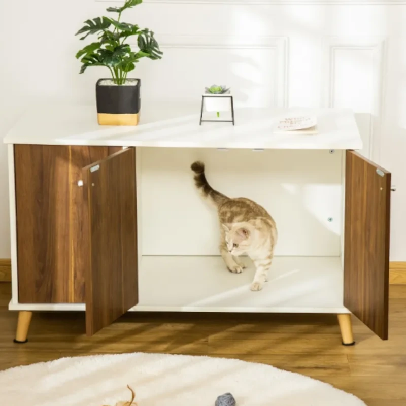 Cat walking inside a cabinet-style litter box hidden within modern furniture.